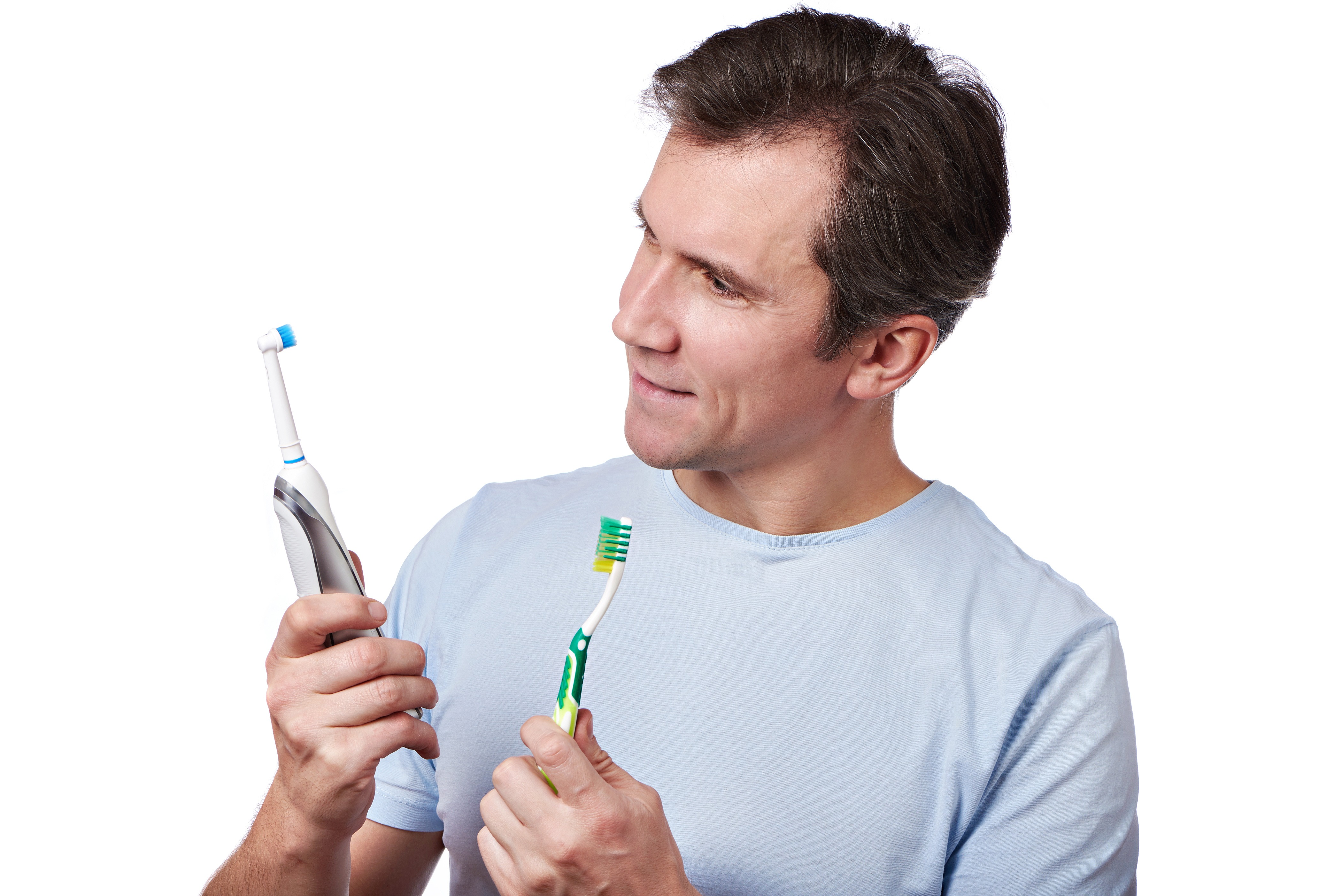 Man chooses between an electric and a manual toothbrush isolated