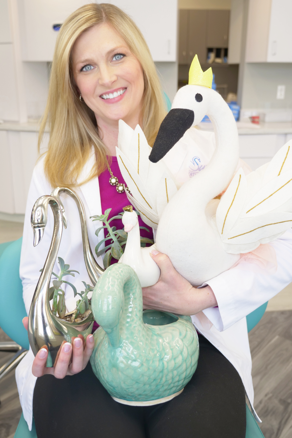 dr. kathryn swan holding a swan vase and stuffed swan